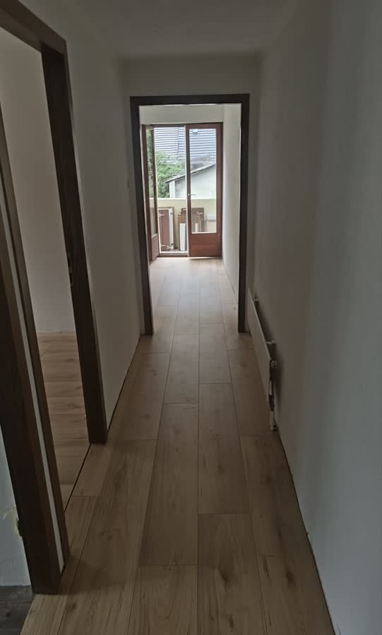 Couloir en cours de rénovation avec un sol en bois clair fraîchement posé.